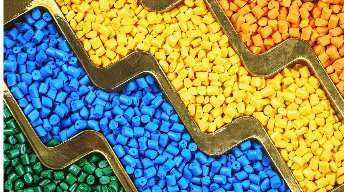 Green, blue, yellow, and orange plastic resin pellets to be used for packaging consumer products