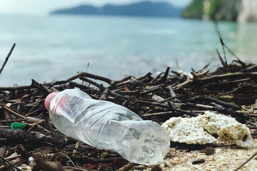 ocean bound plastic beverage bottle on the shore