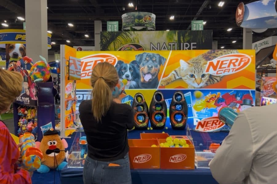 Superzoo 2025 attendees test out Nerf ball shooters at the Nerf Pets booth
