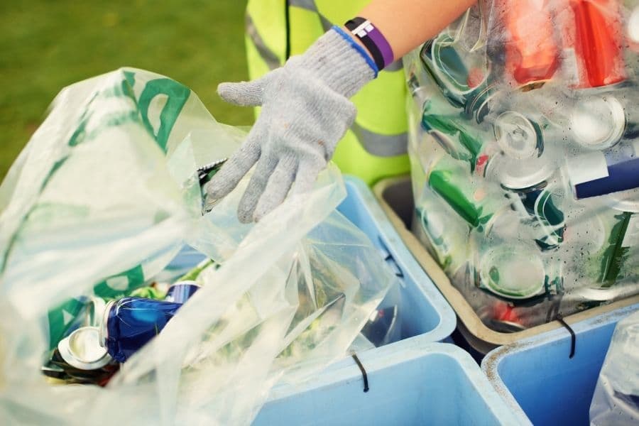 person sorting recycling in separated bins