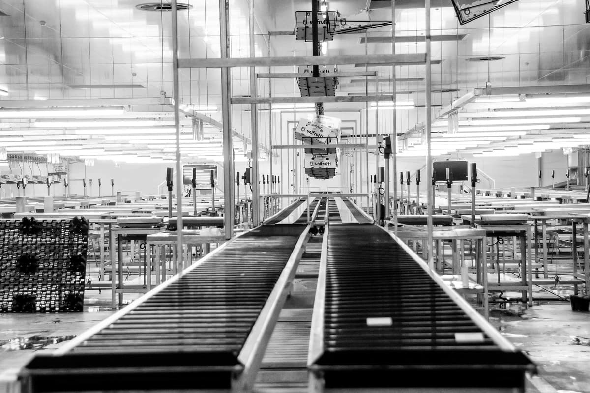 Black and white photo of empty conveyor belt inside a distribution center.